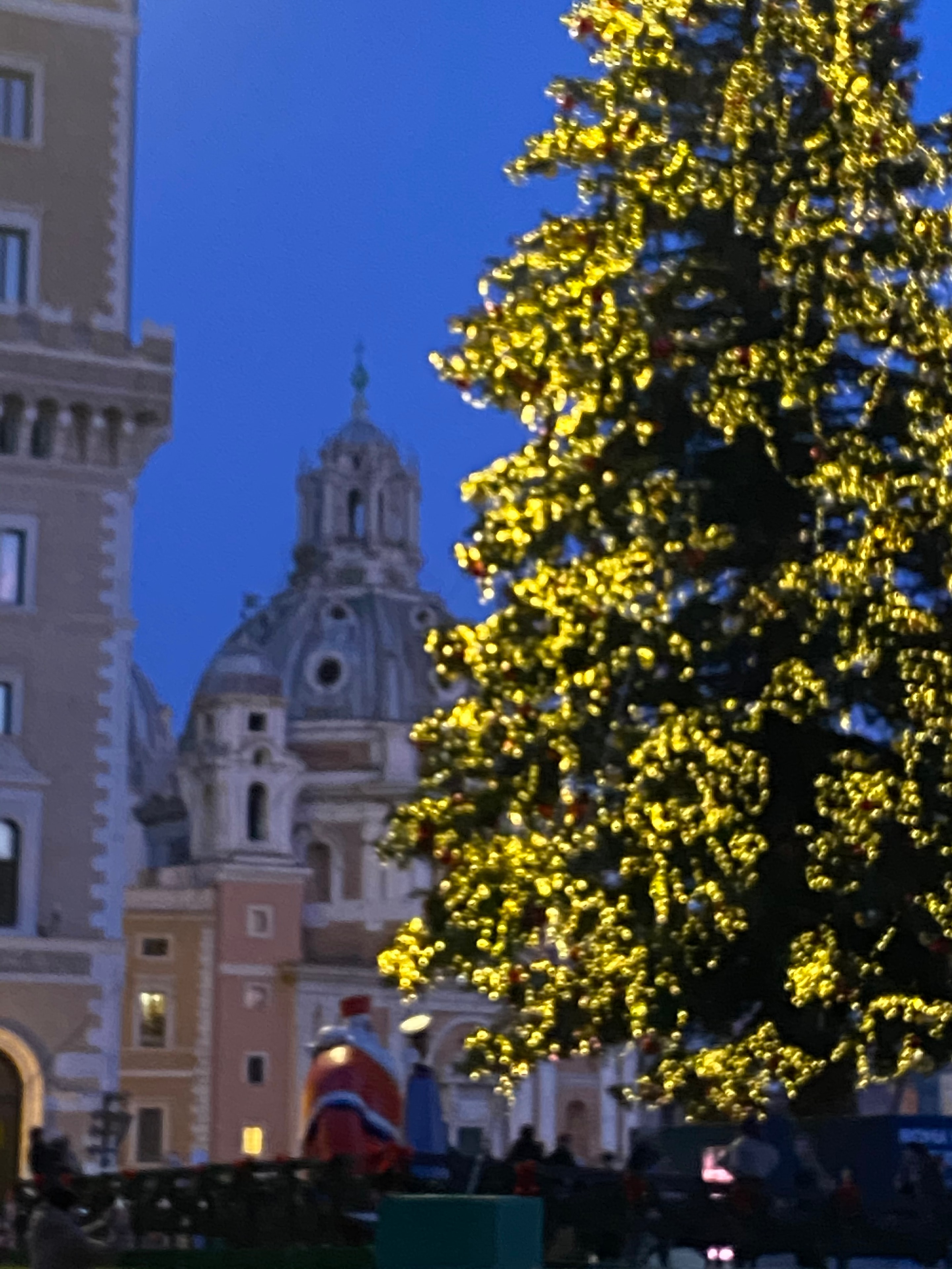 Golden Christmas lights framing baroque church dome Rome at dusk